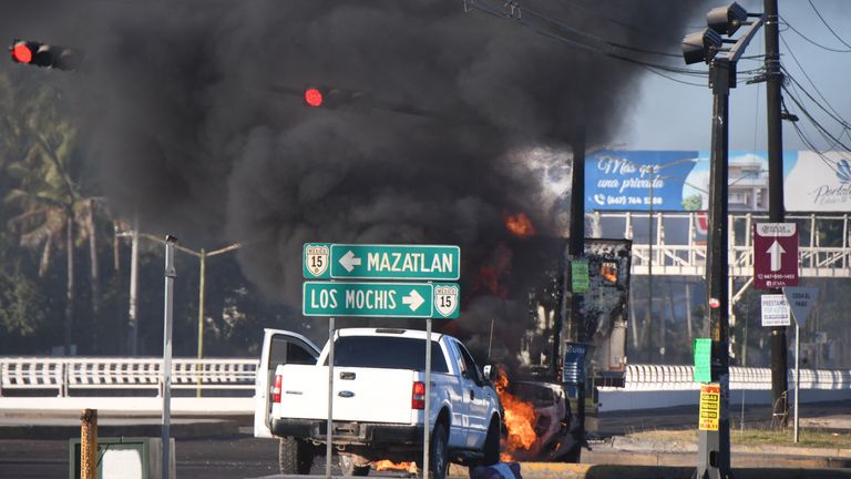 Burning vehicles blocking a road after drug lord Ovidio Guzman&#39;s capture,in Culiacan, Sinaloa