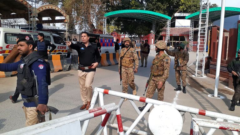 Army soldiers and police officers clear the way for ambulances rushing towards the bomb explosion site 