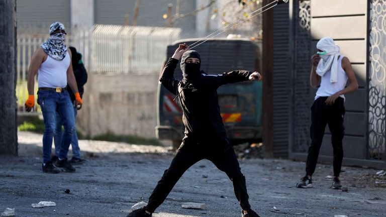 A man uses a slingshot during a clash with Israeli troops in the West Bank 