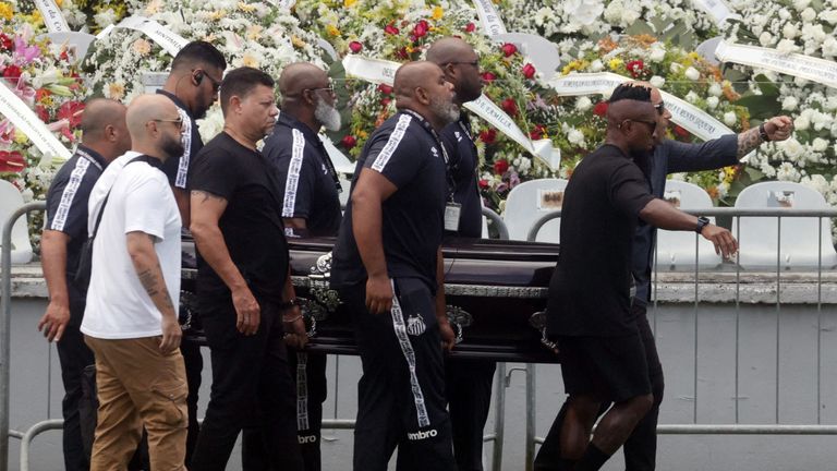 Pallbearers carry the casket of Pele to the centre circle of his former club Santos