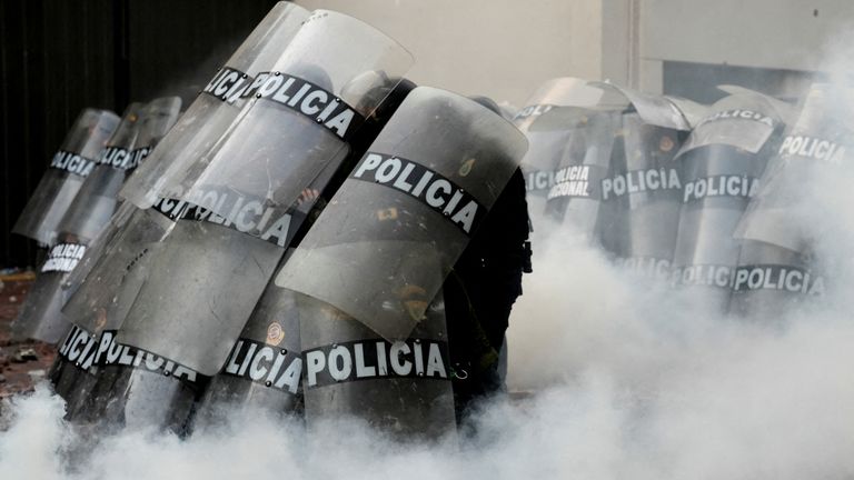 Çevik kuvvet polisleri göstericilerle çatışırken siper alıyor