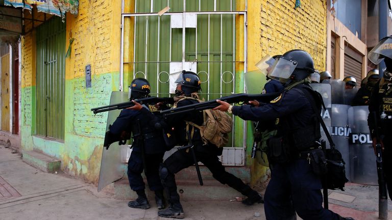 Peruvian police officers operate as demonstrators hold a protest demanding early elections and the release of Peruvian ousted leader Pedro Castillo, in Juliaca, Peru  