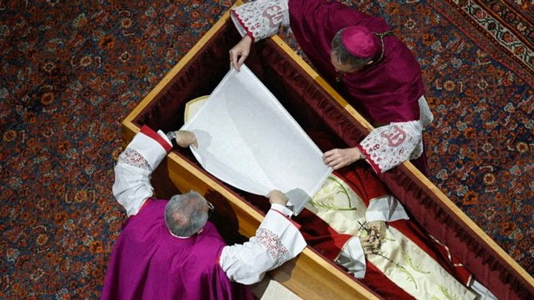 Former Pope Benedict&#39;s face is covered as he lies in a coffin in St. Peter&#39;s Basilica. Pic: Vatican Media/Reuters