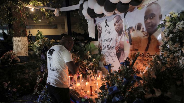 رجل يشعل الشموع على مذبح أقيم لضباط الشرطة الذين قتلوا على أيدي عصابات مسلحة ، في بورت أو برنس ، هايتي ، 30 يناير / كانون الثاني 2023. رويترز / رالف تيدي إيرول