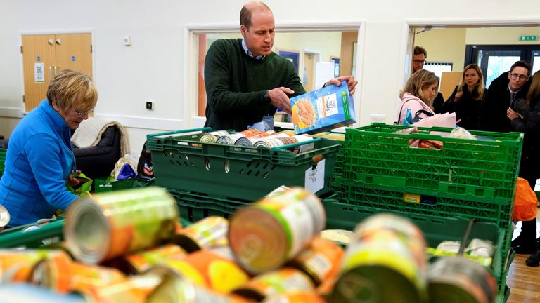 Prince William helps to sort food during a visit to Windsor Foodshare