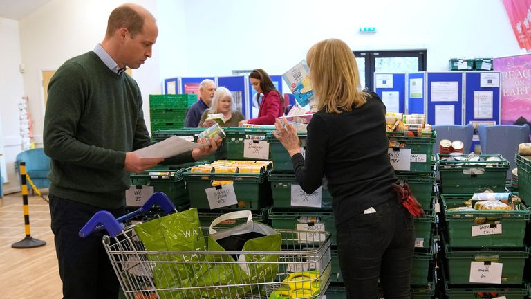 Kate, Princess of Wales, and Prince William check food baskets during a visit to Windsor Foodshare in Windsor
