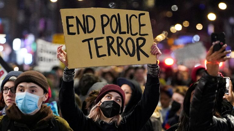 A person holds a sign during a protest following the release of videos showing Memphis police officers beating Tyre Nichols, who died while hospitalized three days later, in New York, U.S., January 28, 2023. REUTERS/David Dee Delgado
