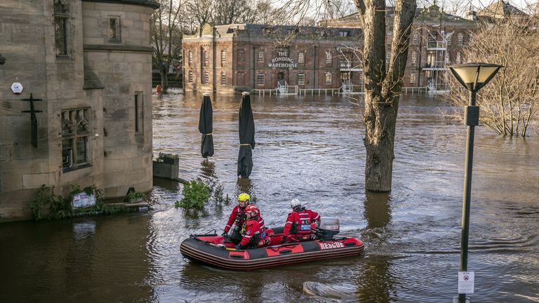 Rescue workers use a boat to navigate the floodwater in the centre of York after the River Ouse burst its banks.