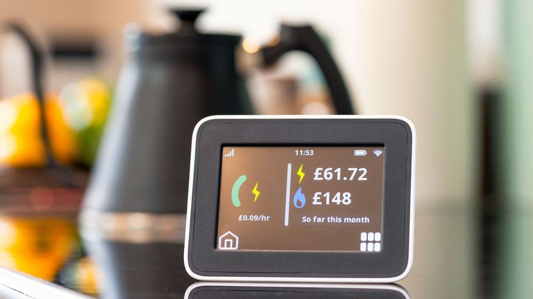 Close-up of the screen of a smart meter display in a kitchen, showing the monthly cost of electricity and gas so far.