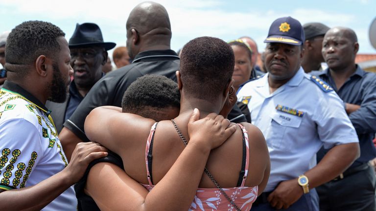 Family members of victims of a mass shooting at a birthday party that left eight dead, comfort one another as South African Police Minister Bheki Cele, and National Police commissioner Fannie Masemola visit the scene of shooting in Kwazakhele, Gqeberha, South Africa. January 30, 2023. REUTERS/Deon Ferreira