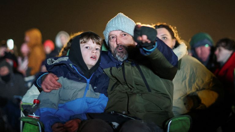 Un homme et un enfant regardent le premier lancement de satellite britannique sur un écran, à l'aéroport de Cornwall Newquay, à Cornwall, en Grande-Bretagne, le 9 janvier 2023. REUTERS/Henry Nicholls