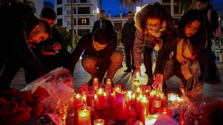 People light candles next to a memorial site during a vigil after the attack