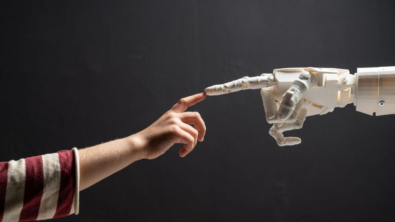 Human Finger Touches Robotic Finger stock photo