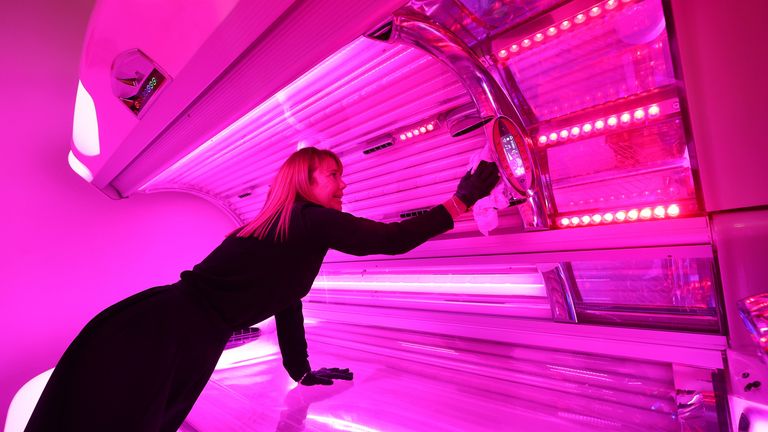 Manager of the store Kerry-Anne Walker sanitises a sunbed at The Tanning Shop on the Isle of Dogs, east London, as they reopen to customers following the easing of lockdown restrictions in England PA Photo. Picture date: Monday July 13, 2020. Nail bars, beauty salons, tattoo and massage studios, physical therapy businesses, spas and piercing services are able to reopen in the latest lifting of restrictions in England. See PA story HEALTH Coronavirus. Photo credit should read: Yui Mok/PA Wire 