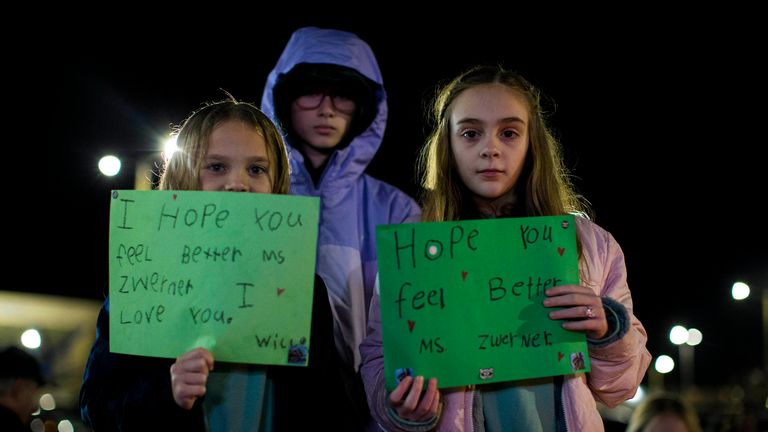 Willow Crawford, left, and her older sister Ava, right, join friend Kaylynn Vestre, center, at a vigil for Abby Zwerner. Pic: AP
