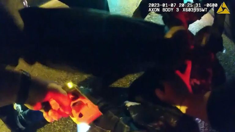 Police hold a taser to the leg of their suspect