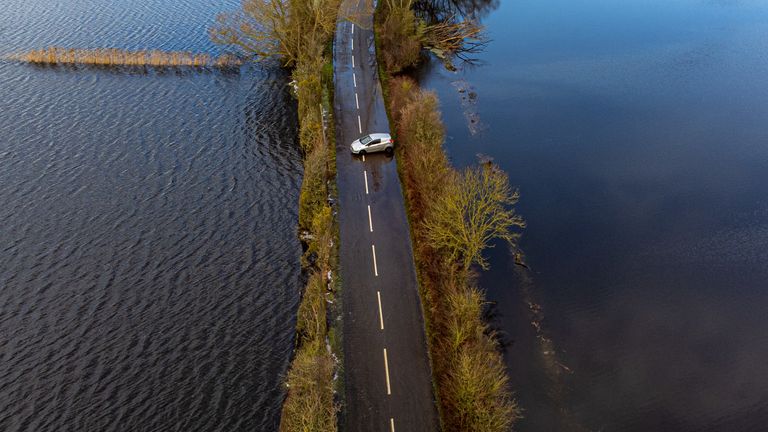 A car turns around on the road approaching floodwater near Muchelney, Somerset