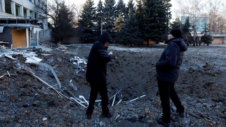 People look at the site of a missile strike that occurred during the night in Kramatorsk
