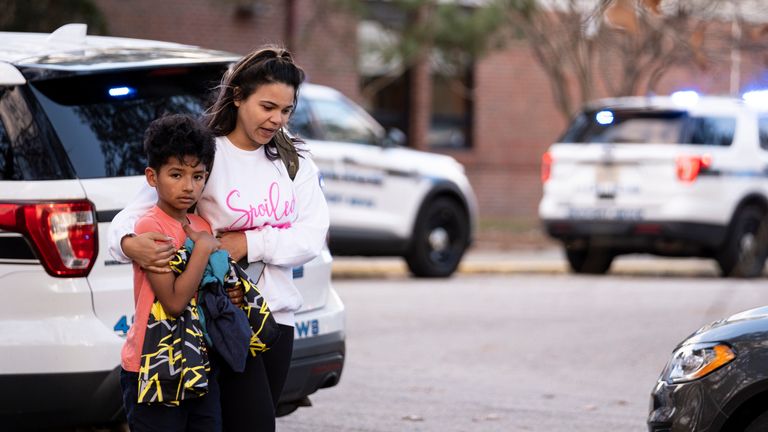 Carlos Glover, age 9,  a fourth grader at Richneck Elementary School, is held by his mother Joselin Glover as they leave the school, Friday, Jan. 6, 2023 in Newport News, Va. A shooting at a Virginia elementary school sent a teacher to the hospital and ended with ...an individual... in custody Friday, police and school officials in the city of Newport News said...(Billy Schuerman/The Virginian-Pilot via AP)