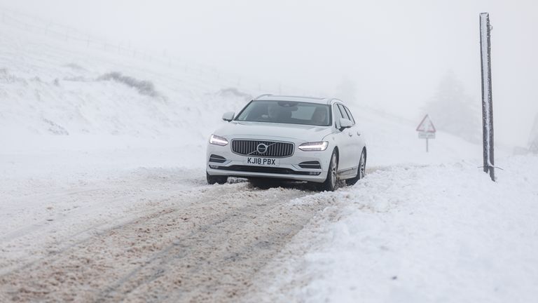 A car makes its way along the A939 after heavy snowfall in the Cairngorms, Scottish Highlands
