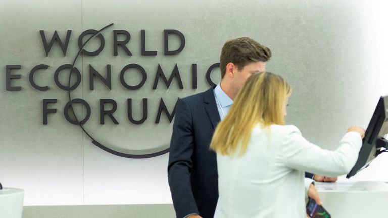 People by the logo for the World Economic Forum