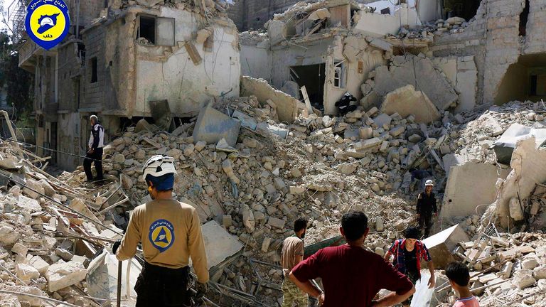 In this picture taken, Tuesday, Oct. 11, 2016, provided by the Syrian Civil Defense group known as the White Helmets, Syrian Civil Defense workers search through the rubble in rebel-held eastern Aleppo, Syria. Activists and rescue workers say an intensive day of bombing on besieged rebel-held parts of Aleppo has left at least 25 people dead, including five children. Rescue workers pulled at least one boy alive from under the rubble late Tuesday night. The Britain-based Syrian Observatory for Hum