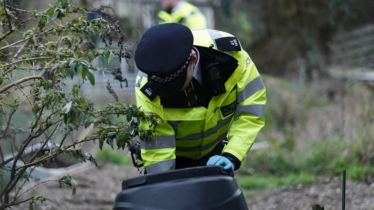 A police officer searches inside a bin in Roedale Valley Allotments, Brighton, where an urgent search operation is underway to find the missing baby of Constance Marten, who has not had any medical attention since birth in early January