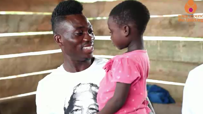 Atsu holds a young girl at Becky&#39;s House, an orphanage he funded in is native Ghana