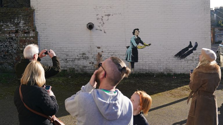 Members of the public look at the new artwork by street artist Banksy, titled Valentine&#39;s Day Mascara