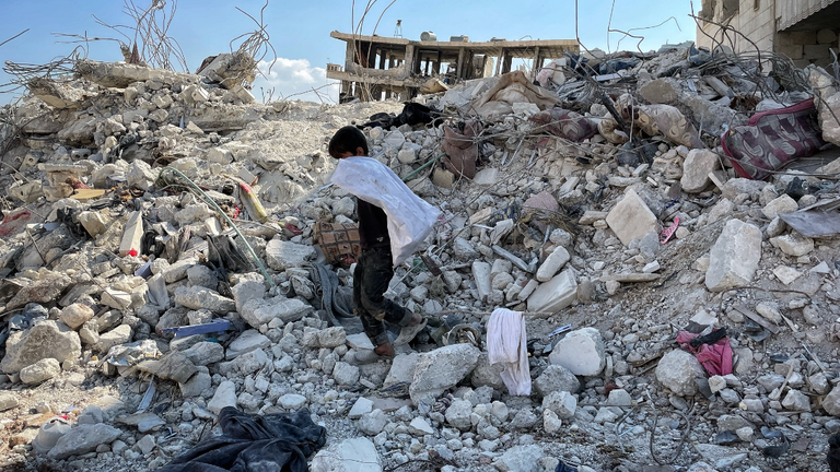 A boy picks through the rubble in Jindiris