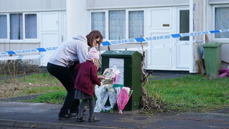 A woman and child arrive to leave flowers at the scene on Broadlands, Netherfield, Milton Keynes, Buckinghamshire, where a four-year-old girl has died following reports of a dog attack in the back garden of a property 