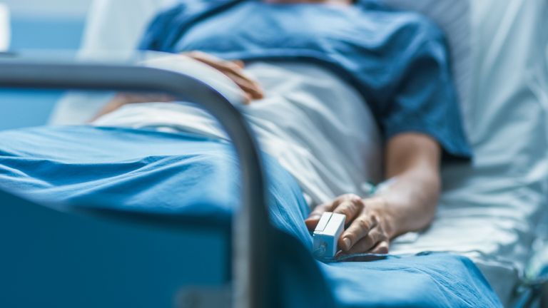 In the Hospital Sick Male Patient Sleeps on the Bed. Heart Rate Monitor Equipment is on His Finger. (iStock)