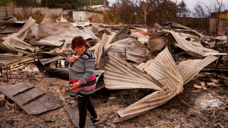 Rose Munoz walks on what is left of home in the city of Tome Pic: AP 