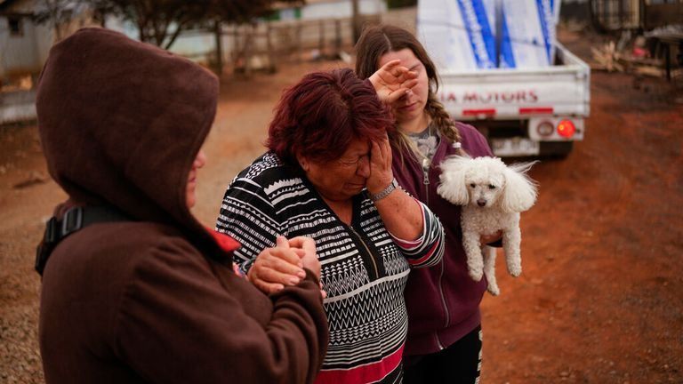 Resident Rosa Munoz (centre) lost her home after wildfires ripped through the city of Tome, in the Biobio region Pic: AP 