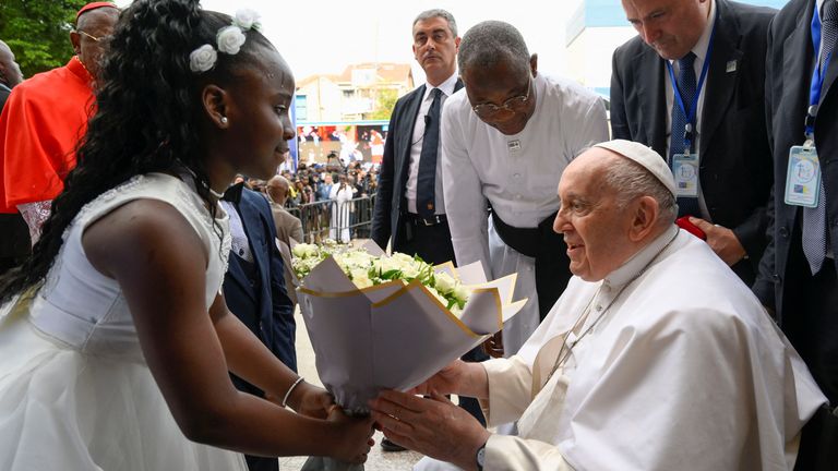 Papa Francis, Demokratik Kongo Cumhuriyeti, Kinşasa'daki havarisel yolculuğu sırasında bir çocuktan çiçek alıyor