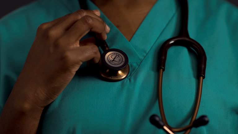 Rahila Dusu, 33, a Junior Doctor at East Lancashire NHS Trust holds her stethoscope as she poses for a portrait ahead of International Women&#39;s Day at The Royal Blackburn Teaching Hospital in north west England, Britain, March 2, 2021. Picture taken March 2, 2021. REUTERS/Hannah McKay