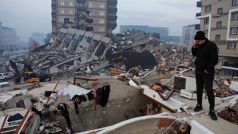 Un homme debout au milieu des décombres regarde les dégâts suite au tremblement de terre à Hatay