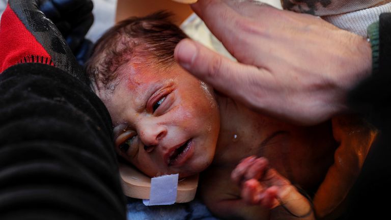 Rescuers hold baby boy Kerem Agirtas, a 20-day-old survivor who was pulled from under the rubble in Hatay