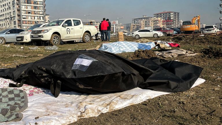 Bodies are put in black bags in Hatay, southern Turkey, following a devastating earthquake. For Alex Crawford report.