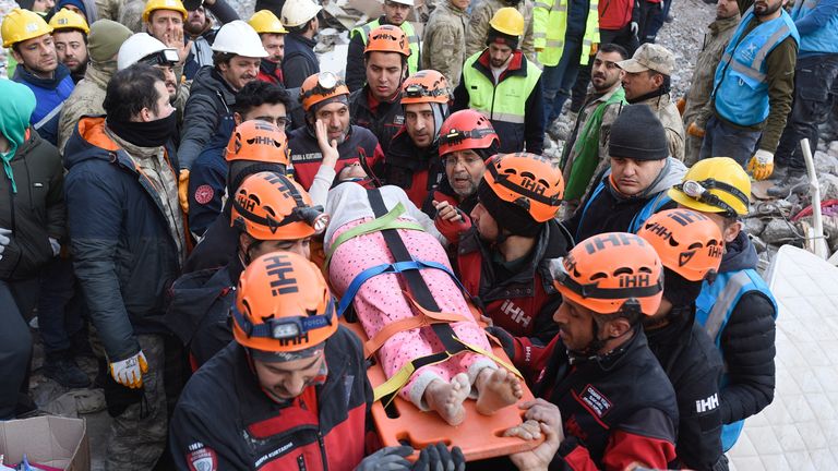 Helin Oktay, who is rescued alive along with her family members, reacts as she is carried to an ambulance after being rescued from rubble, in the aftermath of a deadly earthquake in Iskenderun