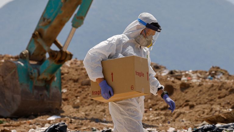 A policeman carries a box of evidence during a search for missing parts on 28-year-old model Abby Choi in Hong Kong, 