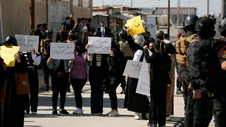 Demonstrators hold placards as they protest against the killing of Tiba Ali. Pic: AP