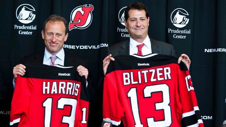 Joshua Harris (L) and David Blitzer hold the New Jersey devil&#39;s T-shirt after a media conference at Prudential center in Newark, New Jersey, August 15, 2013. The New Jersey Devils hockey team was expected to announce on Thursday that Philadelphia 76ers owner Josh Harris has agreed to purchase a controlling interest in the franchise and its arena, pending league approval, media reports said on Wednesday. REUTERS/Eduardo Munoz (UNITED STATES - Tags: SPORT ICE HOCKEY)

