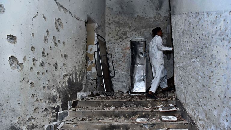 A plainclothes police officer stands beside the bullet-riddled walls after security forces conducting operation against attackers at a police headquarters, in Karachi, Pakistan, Friday, Feb. 17, 2023. Militants launched a deadly suicide attack on the police headquarters of Pakistan&#39;s largest city on Friday, officials said, as the sound of gunfire and explosions rocked the heart of Karachi for several hours. (AP Photo/M. Noman)