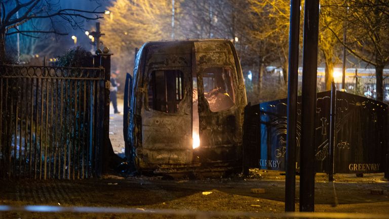 Protesters set a police van on fire outside the Suites Hotel in Knowsley