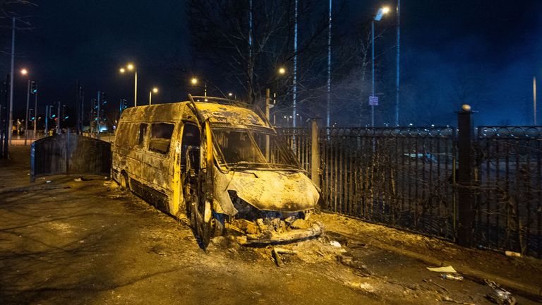 A burnt out police van after a demonstration outside the Suites Hotel in Knowsley, Merseyside
