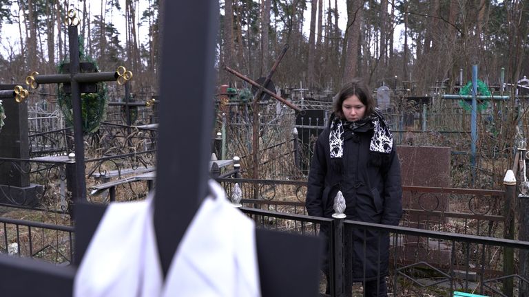 Tetiana Sichkar standing at the grave of her mother 