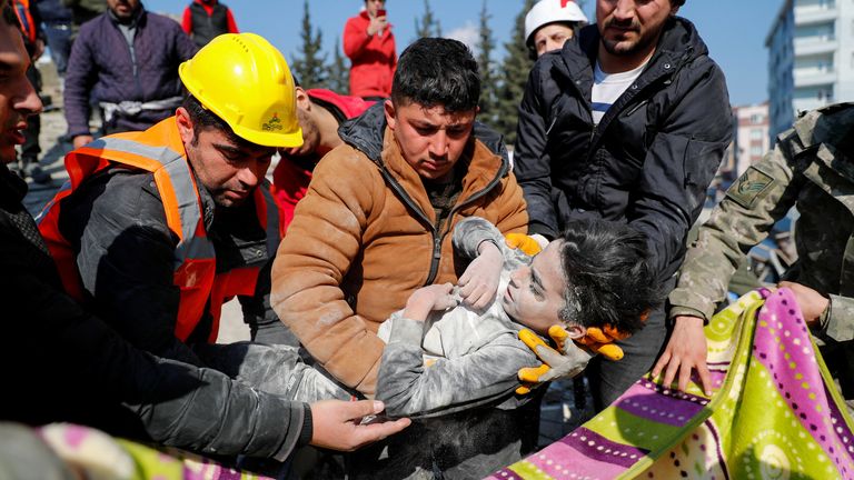Rescuers carry Syrian boy Mehtez Farac, 8, after he was pulled from the rubble in the aftermath of a deadly earthquake in Hatay, Turkey 