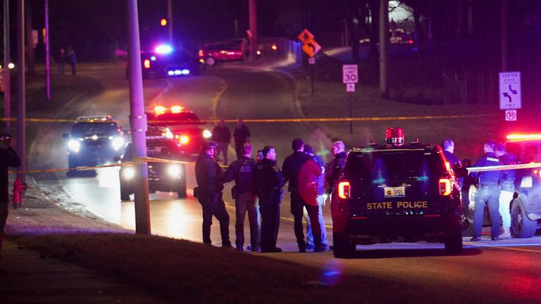 Police officers surround a scene where the suspect was located