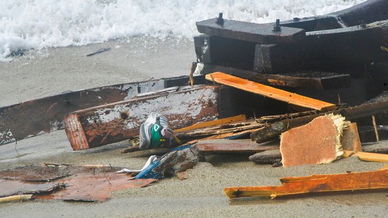 Alabora olan bir teknenin enkazı, 26 Şubat 2023 Pazar, İtalya'nın güneyindeki Cutro yakınlarındaki bir plajda karaya vuruyor. Kurtarma yetkilileri, tekneleri güney İtalya açıklarında parçalandıktan sonra belirsiz sayıda göçmenin öldüğünü ve düzinelercesinin kurtarıldığını söyledi.  (AP Fotoğrafı/Giuseppe Pipita)